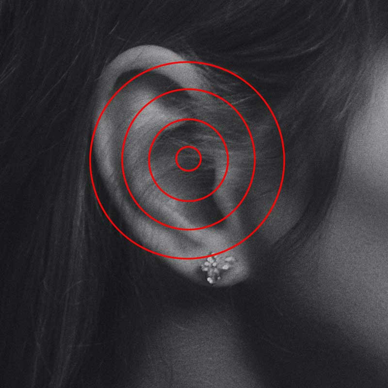 Ohr mit roten Schallwellen-Kreisen als Symbol für Tinnitus