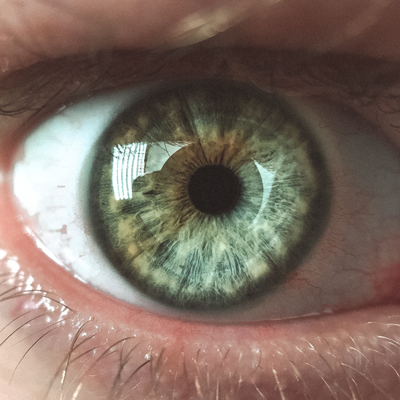 Nahaufnahme eines menschlichen Auges mit grün-brauner Iris